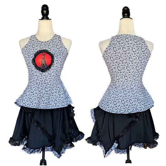 Camiseta gata, falda negra con picos y collar Flores de Lis