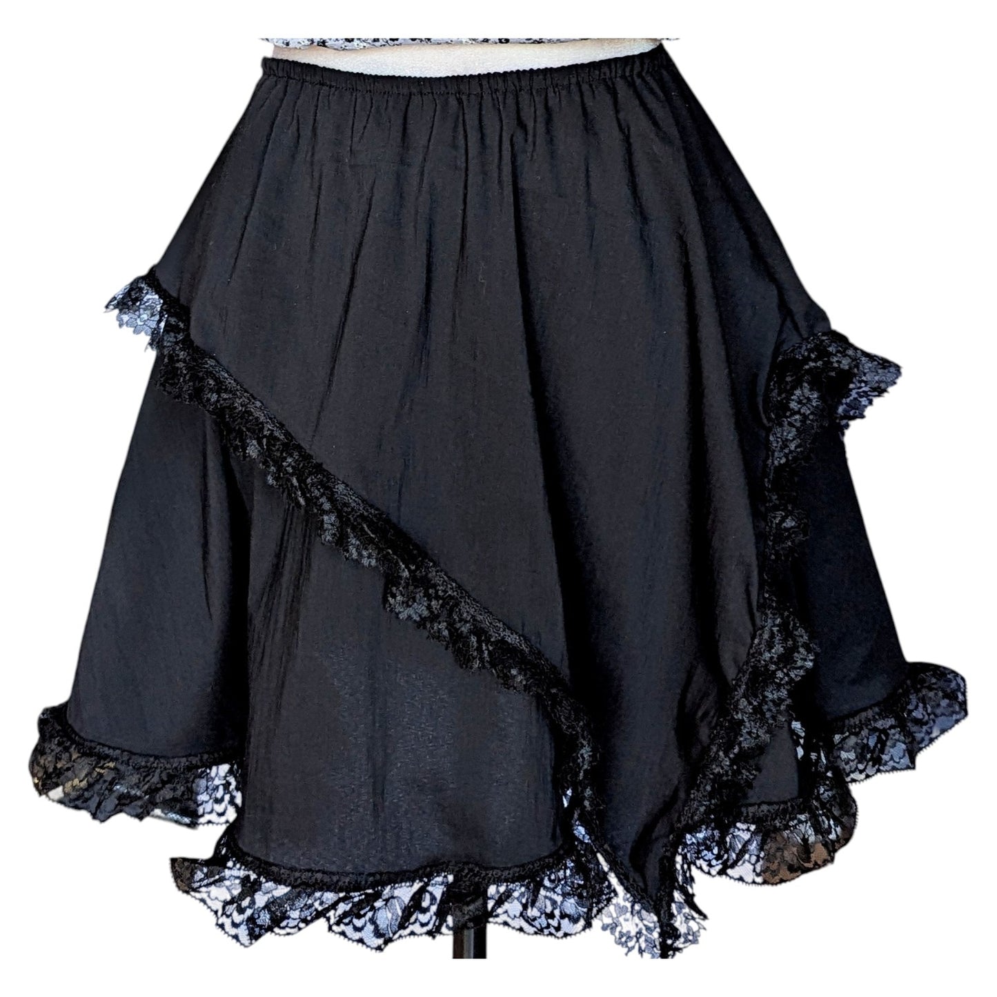 Camiseta gata, falda negra con picos y collar Flores de Lis